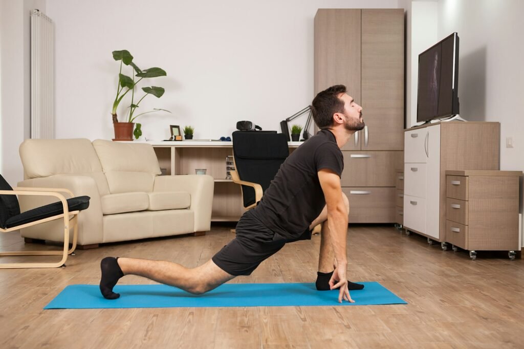 Fit man in his 30s doing yoga on a mattress in his house